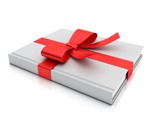 blank white book lying as gift with red ribbon